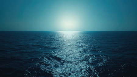 Deep blue sea gradient with glowing sunlight refracting in the water, fading to lighter hues.の素材