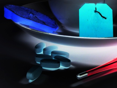 Inverted photo of lemon, teacup, pills and digital thermometerの写真素材