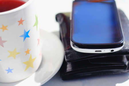 A cup of tea and mobile phone on the table 