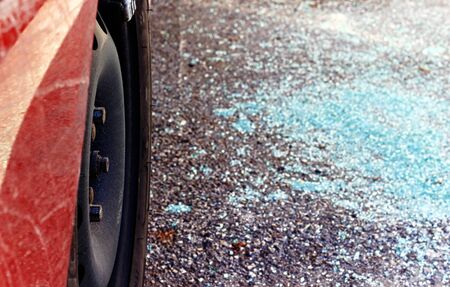Broken glass on the asphalt, near a car; theft stoled values from the carの写真素材