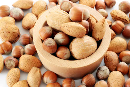 Almonds and hazelnuts in wooden cup の写真素材