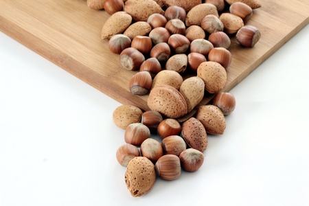 Almonds and hazelnuts on wooden plate 