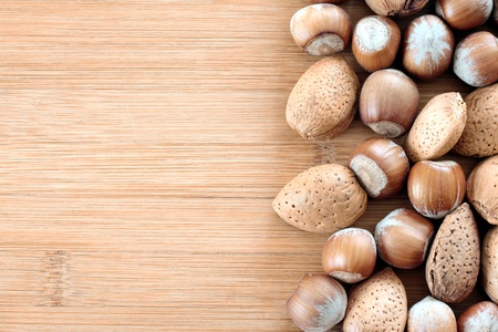 Hazelnuts and almonds on wooden plate の写真素材
