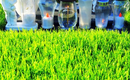 Early grave with white candles on sunny, sad day の写真素材