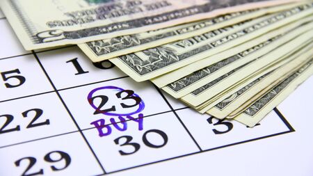 Buying concept with paper money and calendar の写真素材
