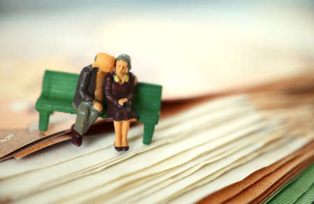 Old couple on a bench. Retired. Pension. Safe in older years. On Euro banknote. Miniature people.の写真素材