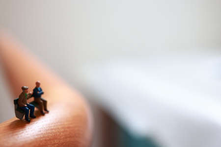 Miniature people sitting on a bed. Selective focus.の写真素材