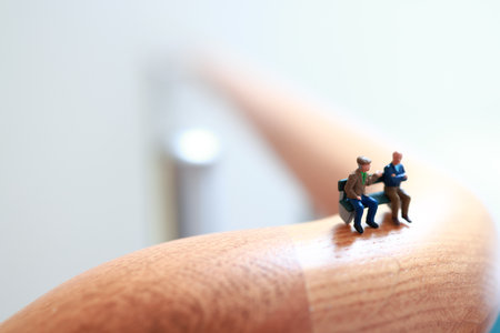 Miniature elder, retired persons on a bench and hook in house. Micro people.の写真素材