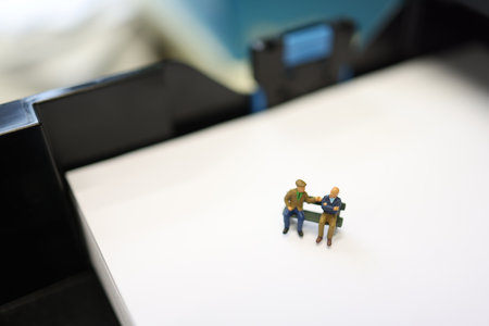Elder people on a bench in real office. Miniature people.の写真素材