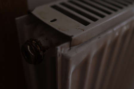 A closeup shot of a dirty heating radiator with a rusty knobの写真素材