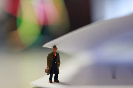Miniature business people under a sheet of envelope paper in real office.の写真素材