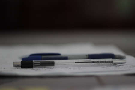 Pen and pencils on a paper. Some notices written down.の写真素材