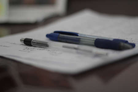 Pen and pencils on a paper. Some notices written down.の写真素材