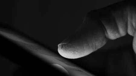 Male finger, damaged, wounded, sliding on a mobile phone.