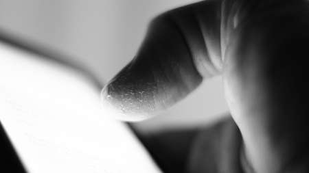 Male finger, damaged, wounded, sliding on a mobile phone.の写真素材