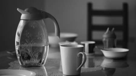 Flask, bottle for water, glasses, dish on a desk in the kitchen.の写真素材