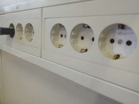 Electrical power strip on the white wall. Close-up.