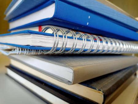 Closeup of a pile of ring binders on a desk.