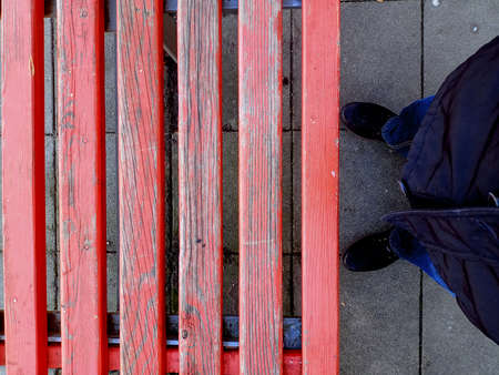 A closeup shot of a person standing on a wooden benchの写真素材
