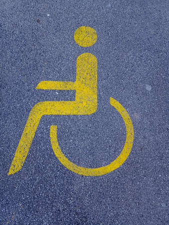 Disabled sign painted on the asphalt road. Wheelchair symbol.