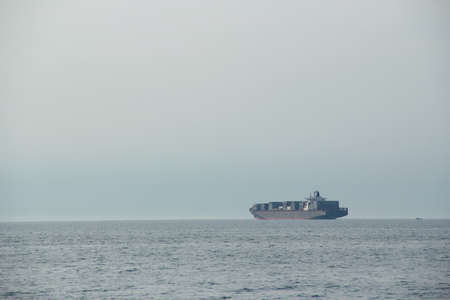 A large cargo ship in the open sea. Freight transportation.