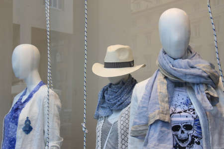 Shop window with mannequins dressed in clothes and hatsの写真素材