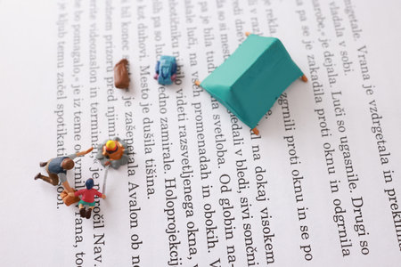 Miniature people working on a book.の写真素材