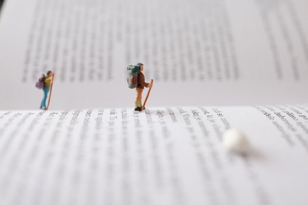 Miniature people : backpacker standing on open book with copy spaceの写真素材