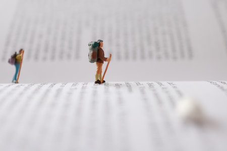 Miniature people : Hiker with backpack standing on open book.の写真素材
