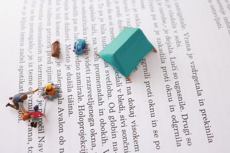 Miniature people working on a paper. Image use for concept