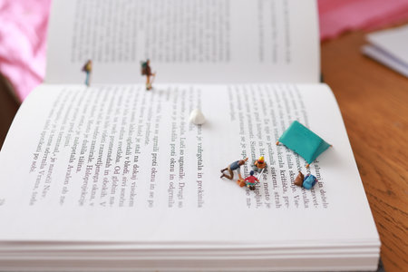 Miniature people reading a book, education concept. selective focus.
