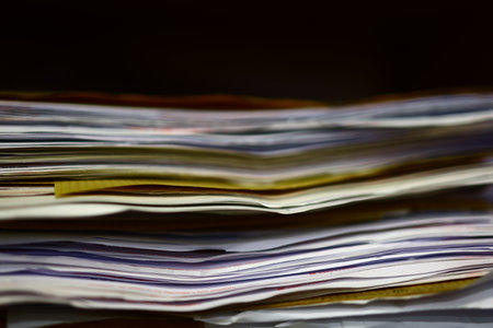 Pile of magazines on a black background. Shallow depth of field.の写真素材