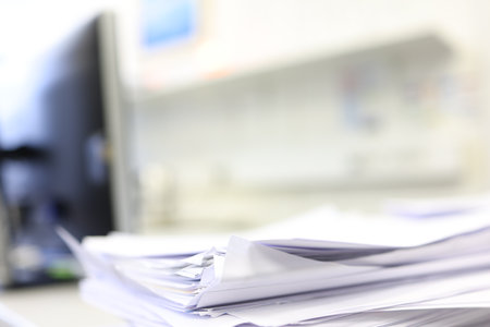 Stack of documents on office desk with blur background, business concept.の写真素材