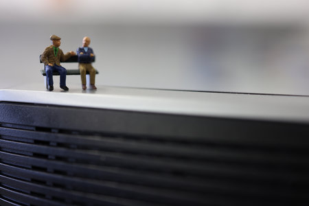 Miniature people: Sitting on a bench. Selective focus.