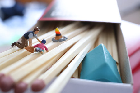 Miniature people playing wooden matchstick. Selective focus and shallow depth of field.の写真素材