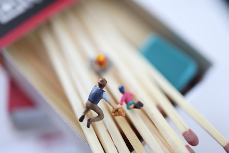 Miniature people : People with matchsticks in a matchbox.の写真素材