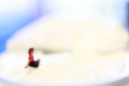Miniature people : Woman sitting on a creme brulee.の写真素材