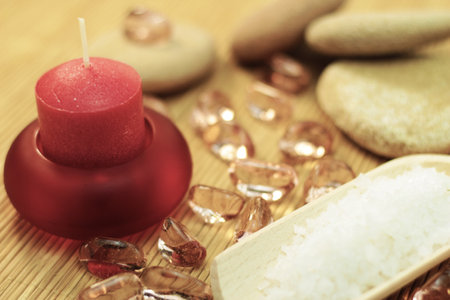 Spa massage setting with sea salt, candle and pebblesの写真素材