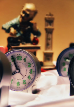 Close up of a clock and a figurine in the background.