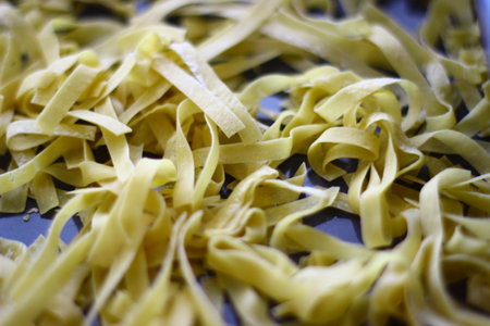 Close-up of uncooked tagliatelle pasta. Food backgroundの写真素材