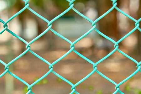 Close up of green wire fence or metal fence net and out of focus background.の写真素材
