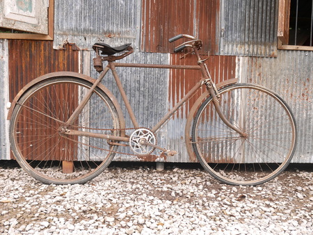 old bicycle was parked beside the old wallの写真素材