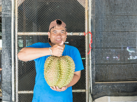 Thai young gardener show his durian from organic gardenの写真素材