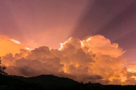 The sun shinning behind the clouds and sky