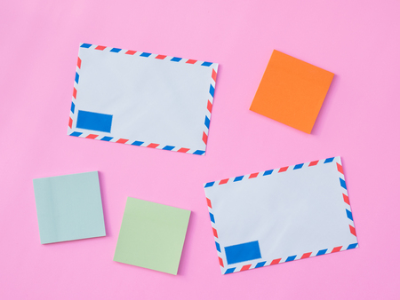 Stationary Background. Flat Lay Photo of Stationary with envelope and post it paper on pink backgroundの写真素材