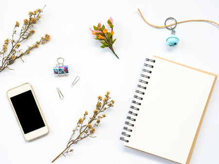 Flat Lay of dry leaf on workspaces with office tools, smartphone and stationary on white background.の写真素材