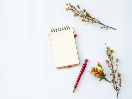 Flat Lay of dry leaf on workspaces with office tools and stationary on white background.の写真素材