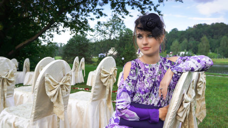 Beautiful girl sitting on a chair in the parkの写真素材