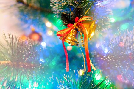 Two Christmas bells on a background of colored lightsの写真素材