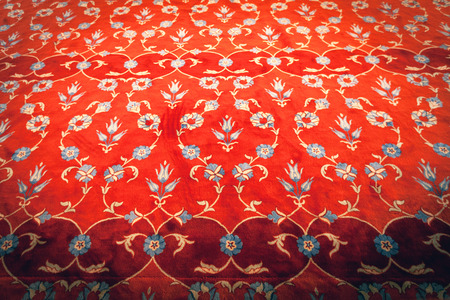 Red carpet with embroidered ornament in the form of tulipsの写真素材
